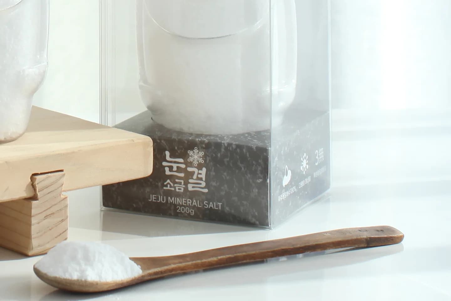눈결소금 포장 상자 옆에 놓인 소금 담긴 나무 스푼