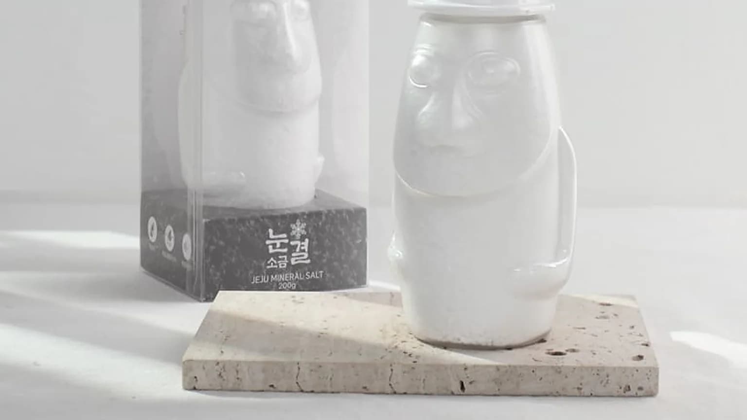 흰 배경에 나란히 놓인 돌하르방 모양 용기 두 점