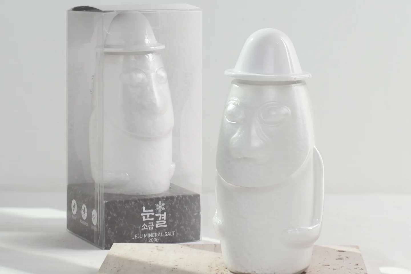 돌 석판 위에 놓인 돌하르방 모양 용기 두 점