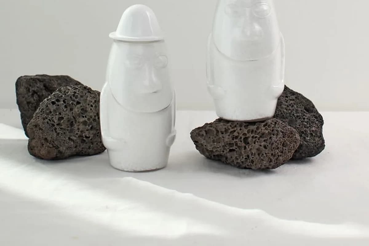 검은 현무암 옆에 놓인 돌하르방 모양 용기